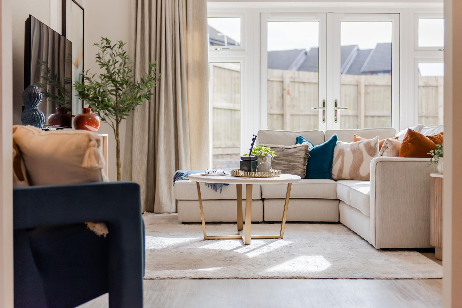 Deanfield Square hero image. Living room with corner sofa and large windows.